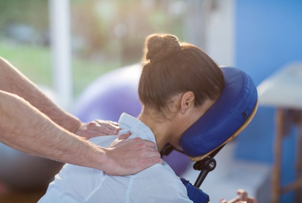 A woman getting her neck treated by a chiropractor.