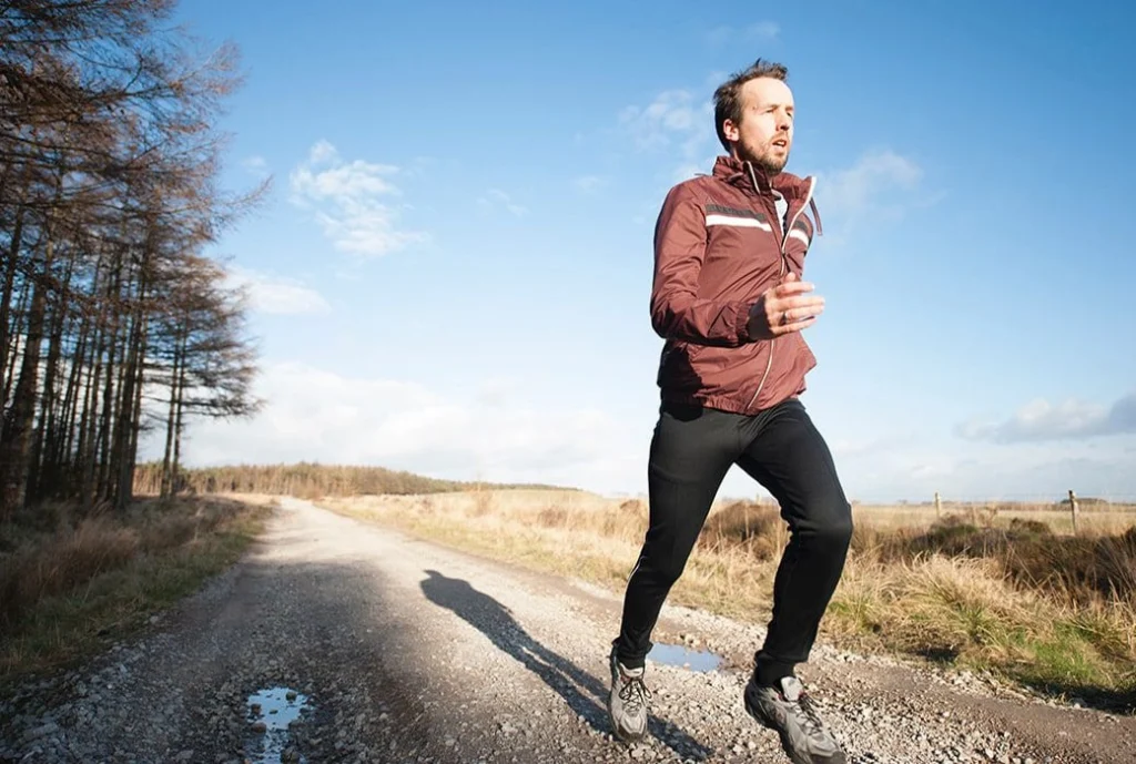 A man jogging in a suburban scenery.