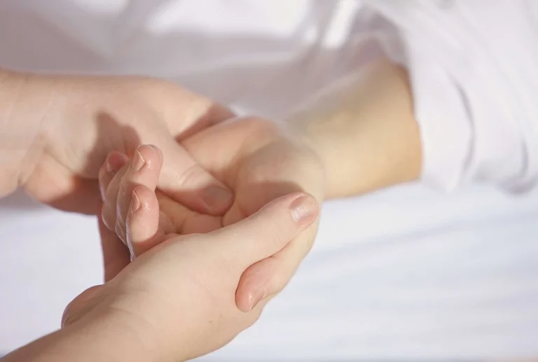 A palm of a hand getting treatment by a chiropractor.