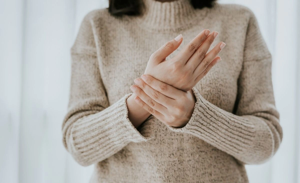 A woman holding her wrist.