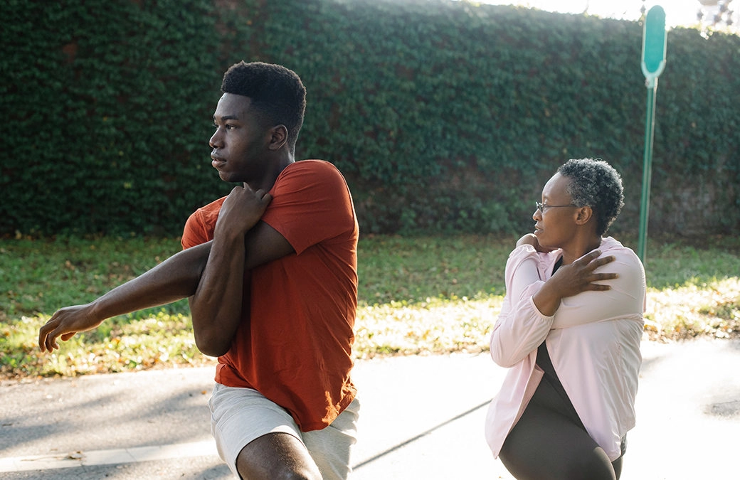 Two people doing arm stretching exercises.