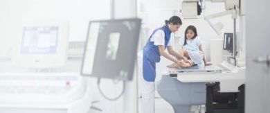 A girl in a hospital room having a doctor examine her.