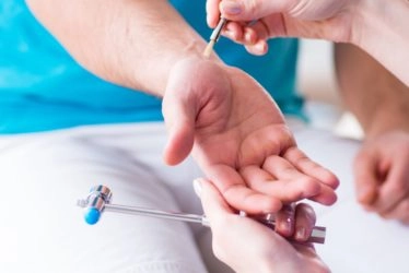 The palm of a hand that is being checked by a doctor for reflexes.