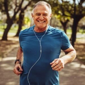 A middle aged man jogging, listening to music.