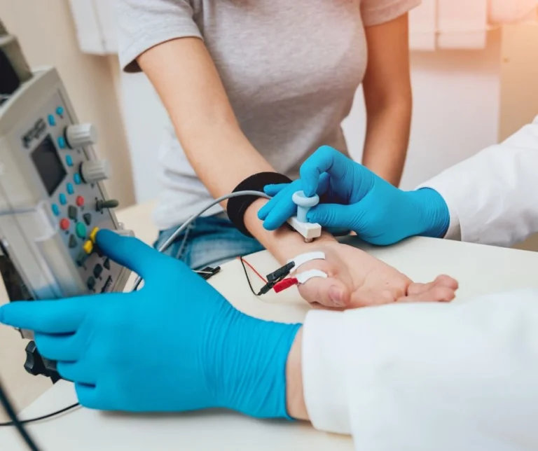 A patient having their hand checked by a doctor.