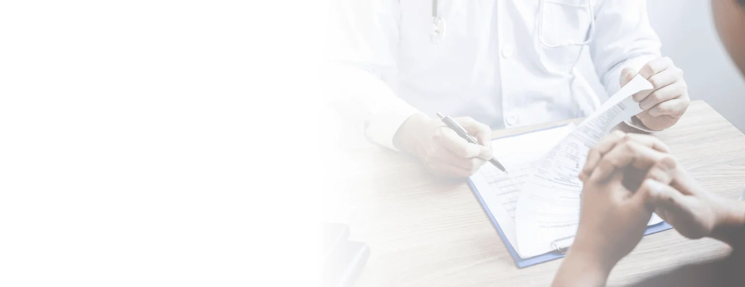 A doctor filling a form in front of a patient.