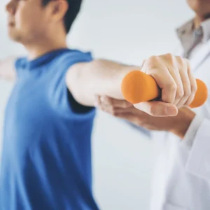 A man doing shoulder exercises with a small weight.