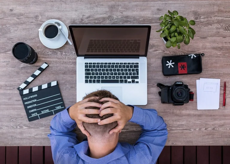 A stressed man in front of a laptop.