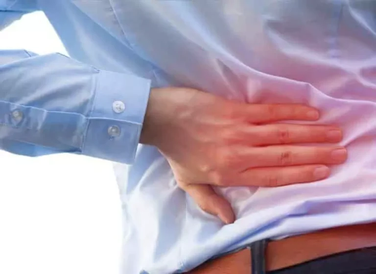 A man touching his lower back highlighted with red color.