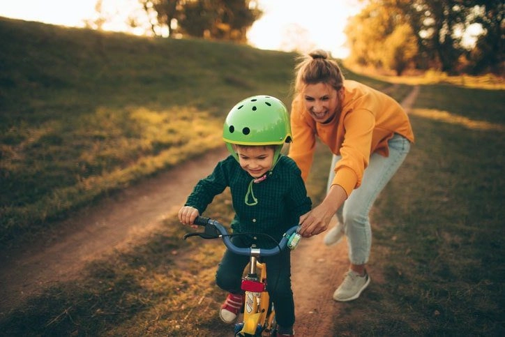 A toddler learning to ride a bicycle.