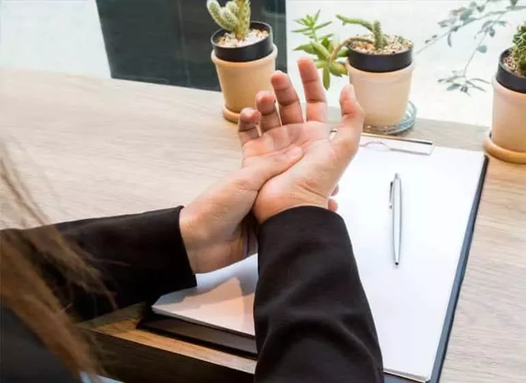 A woman pressing the palm of her hand with her thumb.