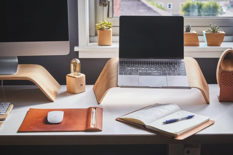 An ergonomic desk setup for laptop and desktop computer.