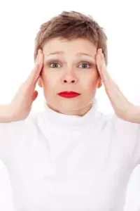 A woman touching her head.