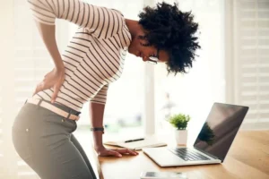 A woman feeling pain in her lower back.