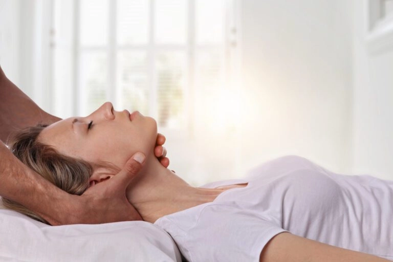 A woman having her neck treated by a chiropractor.