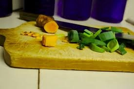 Vegetables and herbs cut in a board.