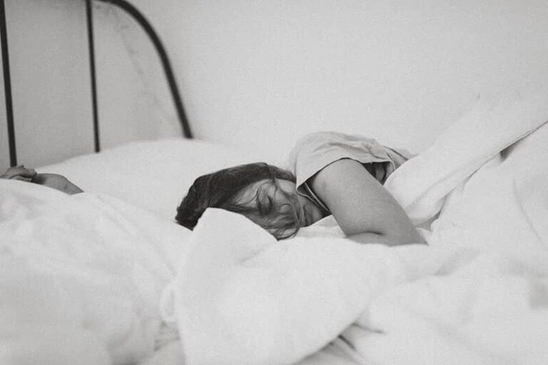 A woman in her bed, sleeping.