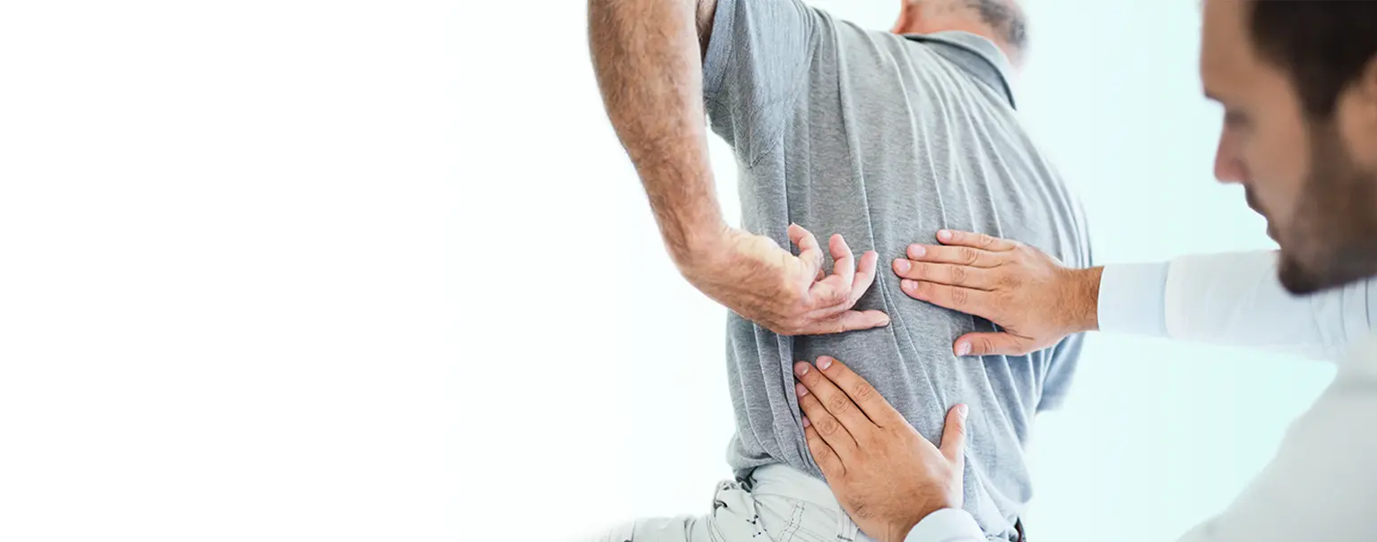 A chiropractor examines a patient's lower back.