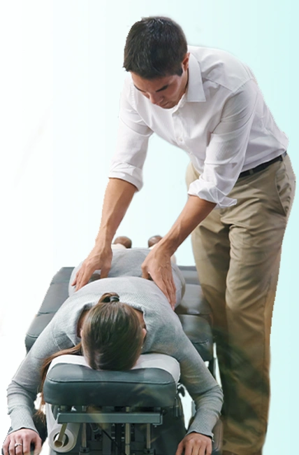 A patient getting massaged for sciatica pain by a chiropractor.