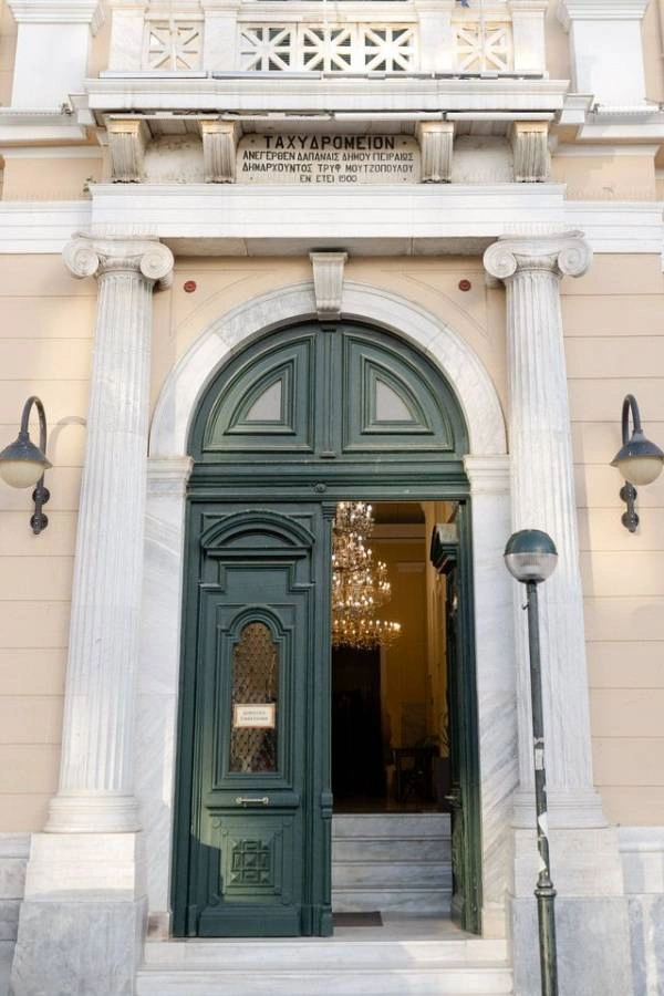 Δικαιολογητικά για πολιτικό γάμο: Ο πλήρης οδηγός (2025) 4 Είσοδος του ιστορικού Ταχυδρομείου με πράσινη πόρτα και μαρμάρινες κολώνες.